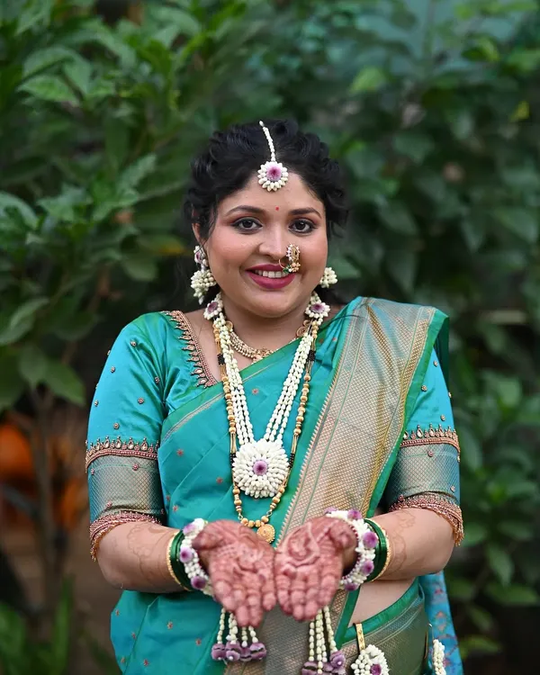 The beautiful mom-to-be, ready for her Dohale Jevan ceremony. Her look is completed with delicate floral jewelry, a Maharashtrian tradition for this special occasion.