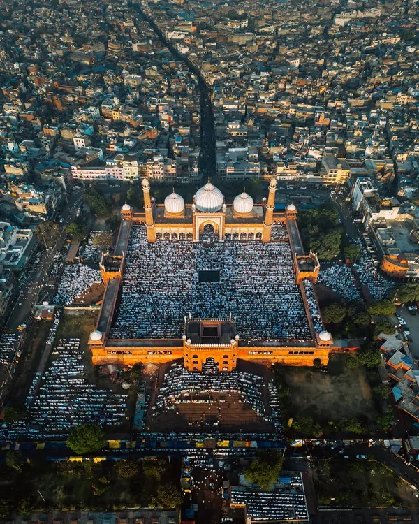 An aerial view of thousands gathered for Eid-ul-Fitr prayers at the historic Jama Masjid in Delhi. This frame captures the immense scale of faith and community against the backdrop of the sprawling city.