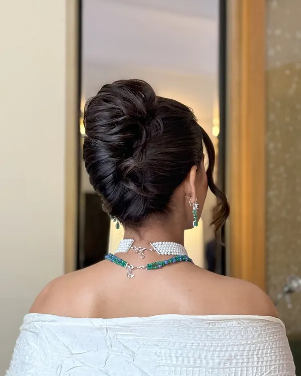 A detailed look at a voluminous, textured updo. I crafted this bun to have height and intricacy, making it a statement piece that looks stunning from every angle, perfect for an elegant evening function.