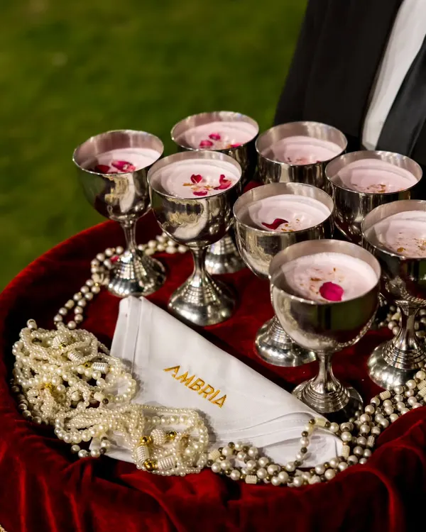 An elegant welcome. Chilled rose milk served in beautiful silver goblets on a velvet tray, offering a refreshing and traditional start to the festivities.