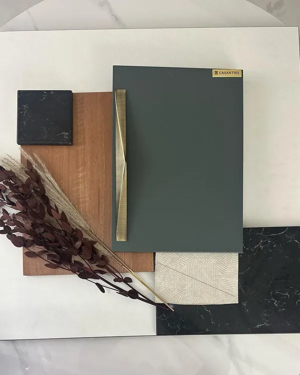 The design process starts with a mood board to capture the right feeling. Here, I've combined samples of wood, marble, and fabric with a subtle sage green and a touch of rustic gold to define the material palette for a project.