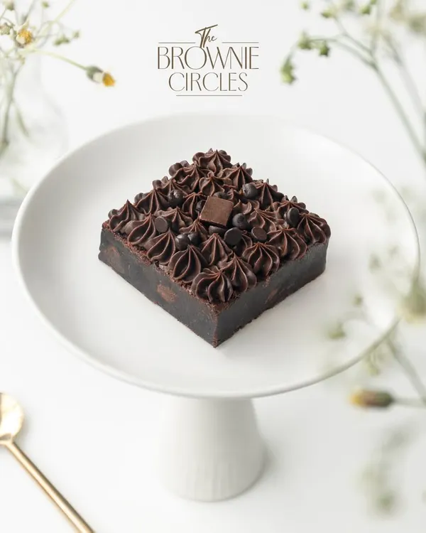 This is where it all began: the quest for the perfect fudgy brownie. Our Chocolate Overload brownie is made with pure couverture chocolate and real butter, creating a rich, dense texture that's never cakey. It's the heart of our brand in every single bite.