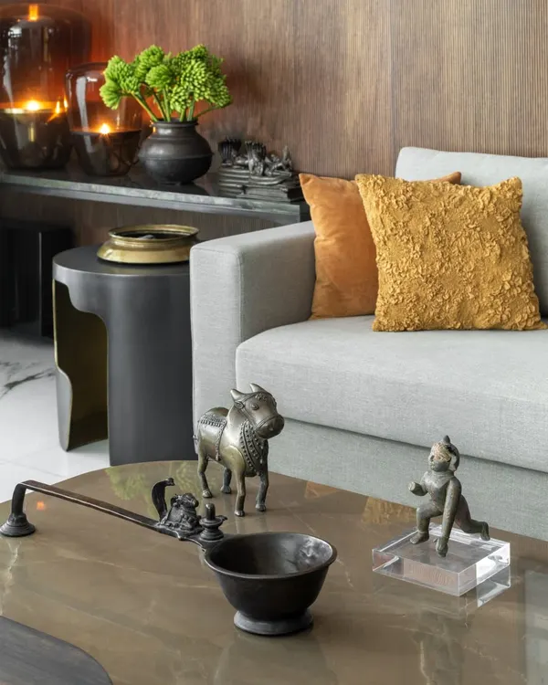 A close-up on a coffee table reveals the quiet choreography of objects. Here, antique bronze sculptures from our personal collection sit alongside contemporary furniture, telling a story that spans time and geography. These details are what give a space its soul.