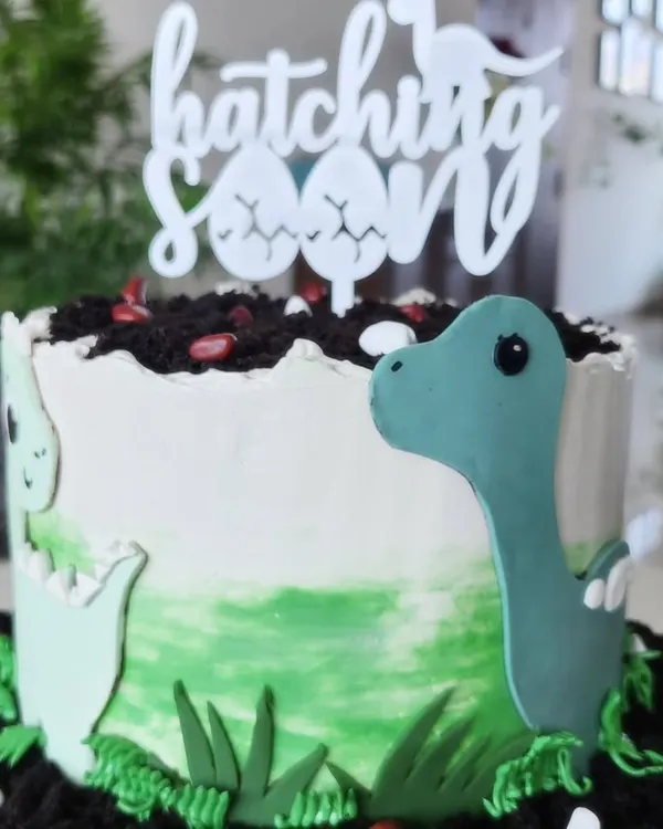 This dinosaur-themed cake was for a very special baby shower to celebrate a "hatching soon" arrival. It's a chocolate and fresh strawberry cake, and I loved creating the little fondant dinosaurs and edible soil to bring the theme to life.