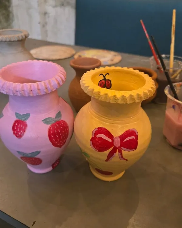 Look at these adorable creations. After you've shaped your piece, you get to bring it to life with color. These two hand-painted vases show just how personal you can make your art.