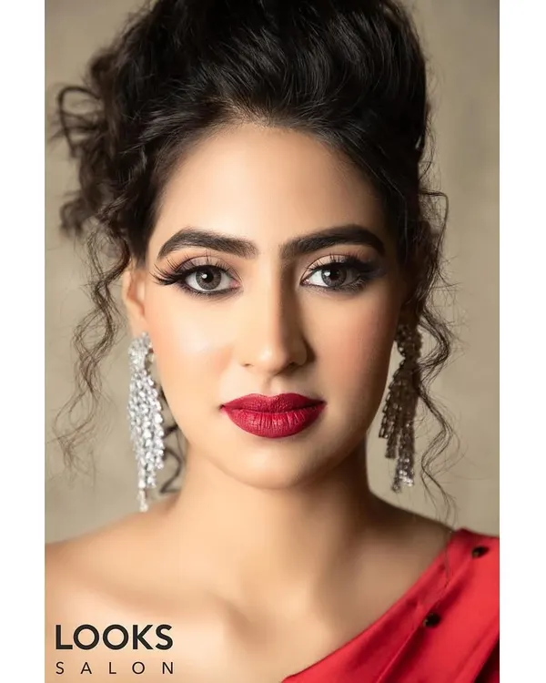 A classic party look featuring a bold red lip and defined eyes. This close-up shows the flawless base and crisp eyeliner, a timeless combination that exudes confidence and glamour for any evening event.
