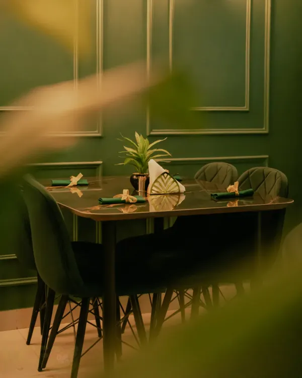 A view of the dining setup at my restaurant. The elegant green decor and comfortable seating create a welcoming atmosphere.