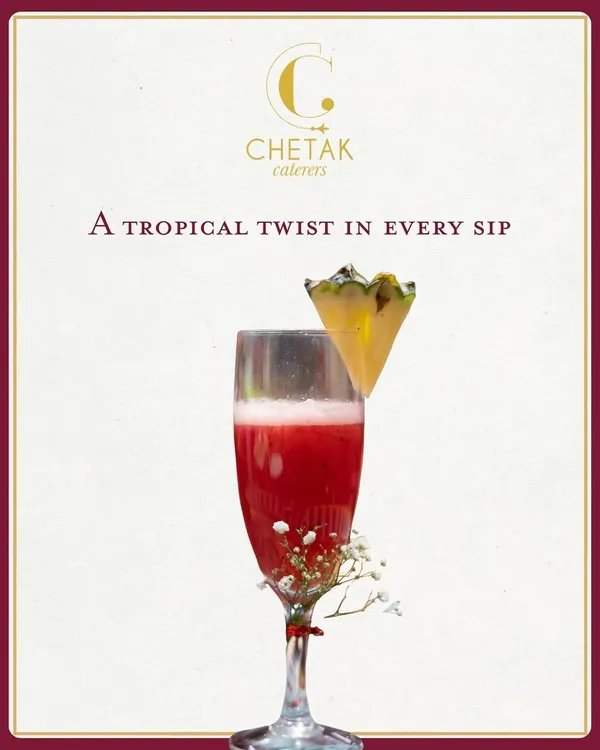 A tropical twist in every sip. This vibrant red mocktail, garnished with a slice of pineapple, is a refreshing and elegant welcome drink for any celebration.