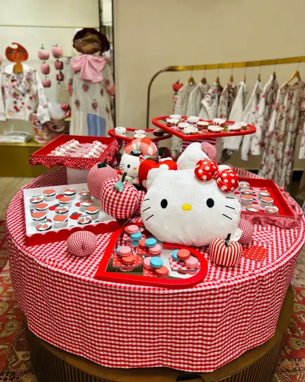 The full grazing table I curated for the Hello Kitty x Péro showcase at Good Earth. The setup features custom cupcakes, macarons, and other themed treats arranged on a red-and-white gingham tablecloth.