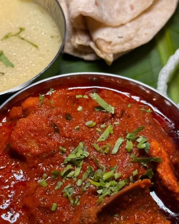 A close-up of my Mutton Kolhapuri with Pandra Rassa, served with soft chapati and crispy rice papads. This was from the Kolhapuri Konkan Food Express pop-up, a truly memorable event.