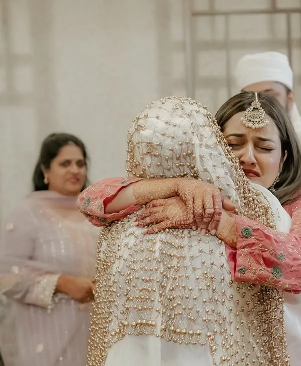 The emotional farewell. A bride shares a tearful hug with her sister, a powerful and candid moment that speaks volumes about their bond. We capture these heartfelt goodbyes with sensitivity.