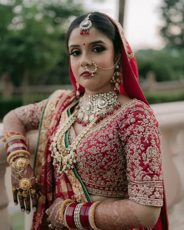 A timeless bridal look, capturing the elegance and grace of a traditional wedding day. This look features classic red and gold tones, with detailed eye makeup and flawless skin to ensure the bride looks and feels regal.