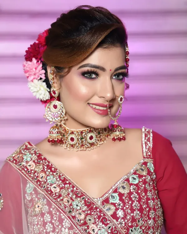 A beautiful glam look with a floral bun. The makeup is bright and festive, perfect for any celebration.