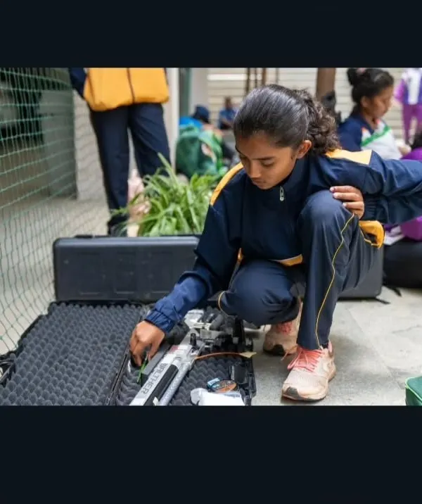 Preparation is key. A young shooter carefully arranges her equipment before a competition. We teach our athletes the importance of discipline in every aspect of the sport.