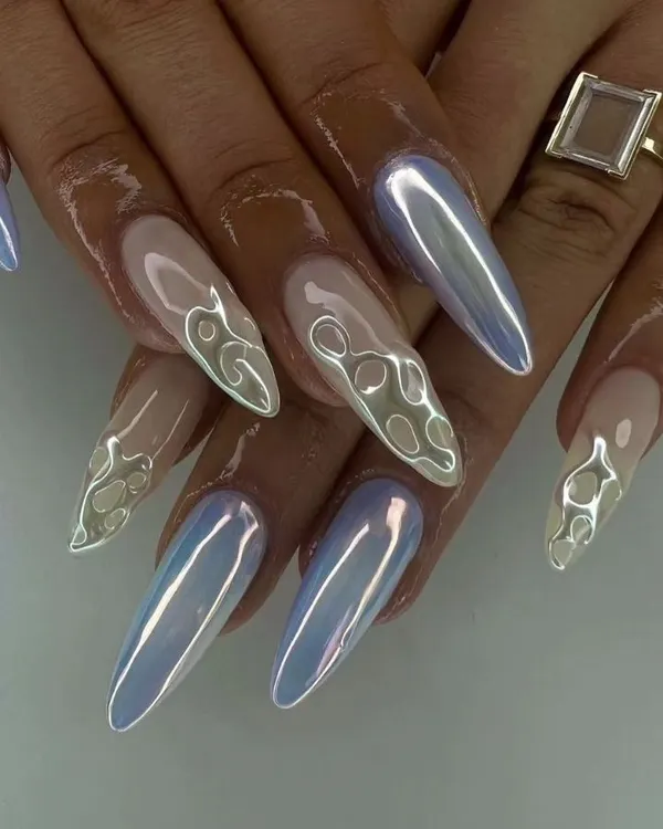 An iridescent chrome finish on long stiletto nails. This set features a mix of full chrome and 3D flame outlines for a futuristic look.