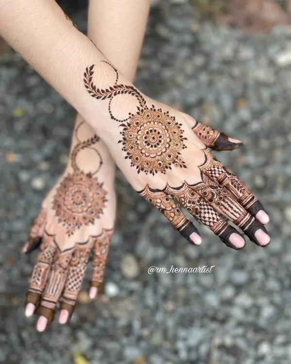 A beautiful and intricate mandala design. I love how the pattern radiates from the center, with delicate details on the fingers and a leafy vine on the wrist.