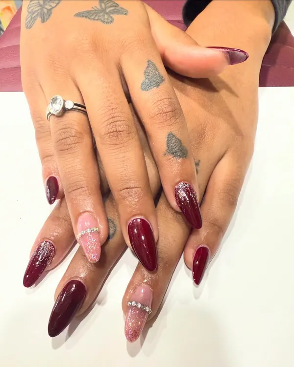 A beautiful set of deep red almond nails. I combined the solid color with accent nails featuring pink glitter and a rhinestone band, giving a classic manicure a modern, glamorous twist.