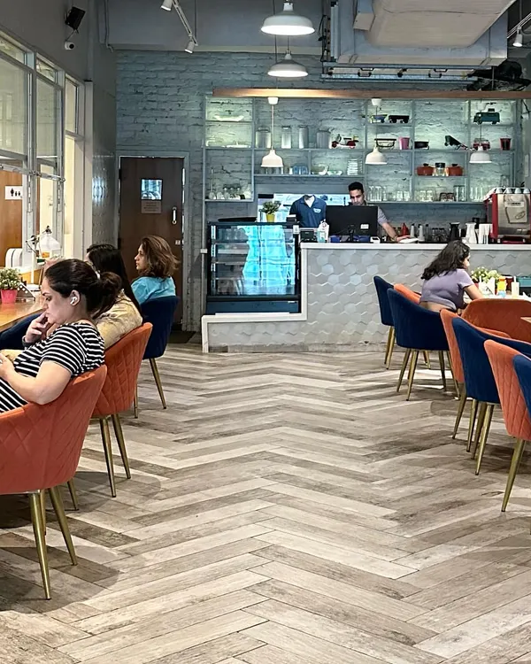 I designed the cafe to be a stylish and comfortable retreat for parents. With modern herringbone floors, cozy chairs, and a clear view of the play area, it's a space where you can truly unwind.