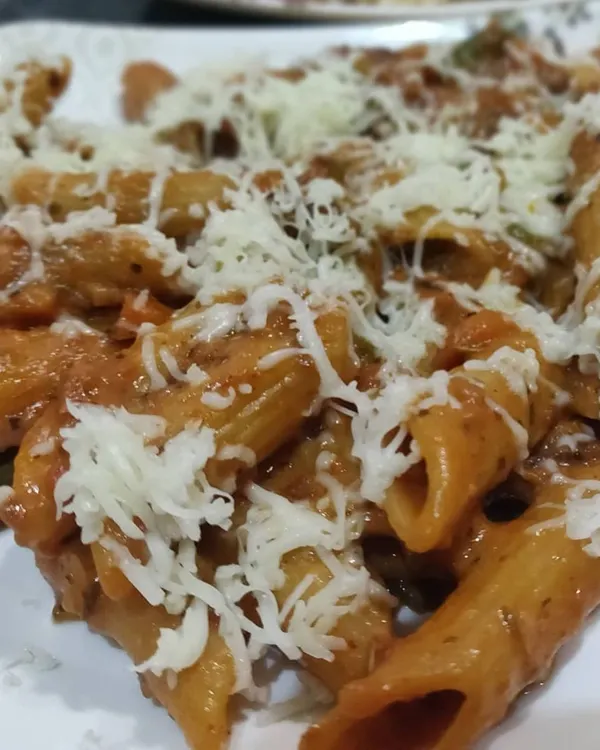 A hearty plate of penne pasta tossed in a rich red sauce and generously topped with shredded cheese. A crowd-pleaser for all ages.