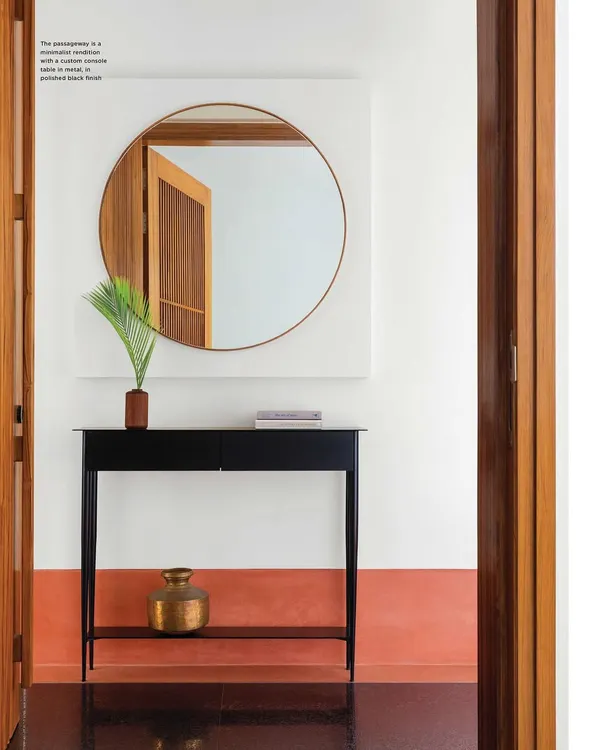 Our Ved House project was featured on the cover of Livingetc India. This shot of the entryway shows the minimalist black console, circular mirror, and the striking contrast between the black granite floor and terracotta-hued skirting.