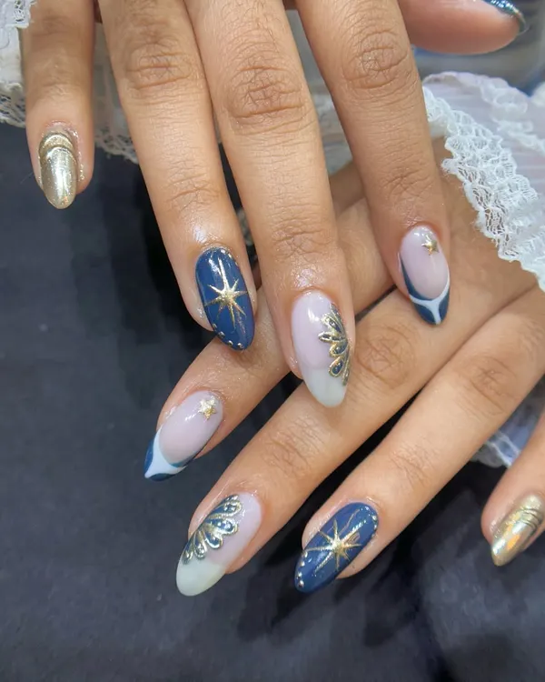 This intricate celestial design is one of my favorites to create. I used a deep navy gel polish as the base and carefully hand-painted the gold starbursts and accents to give it a stunning, luxurious feel on natural nails.