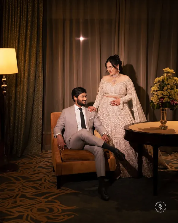 An elegant reception portrait of the couple in a luxurious hotel room, showcasing their sophisticated style. I use the ambient light to create a warm, intimate mood.