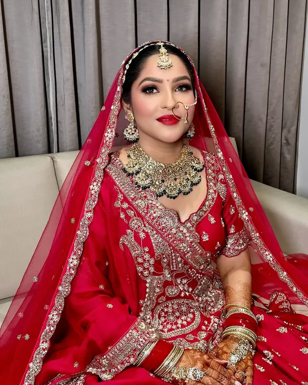 This is the quintessential bridal look that I absolutely adore creating. It features a flawless base, classic winged eyeliner, and a bold red lip that makes my bride look and feel like royalty on her wedding day.