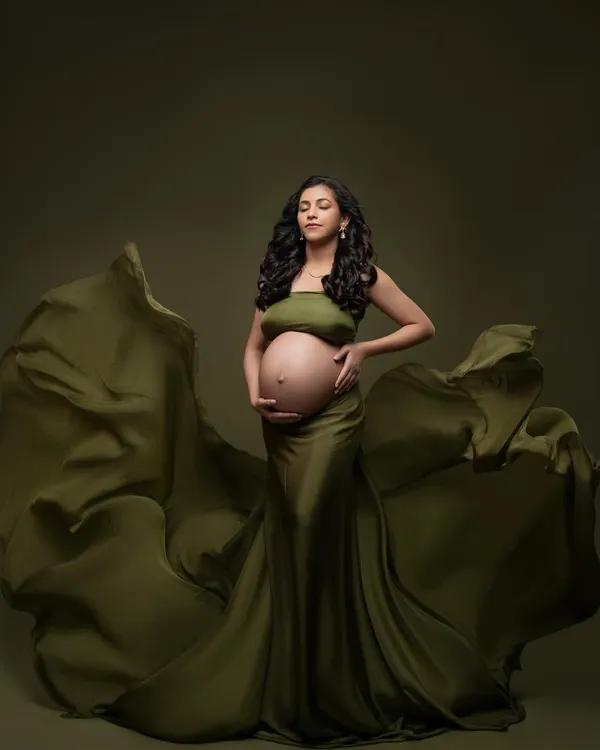 A moment of quiet reflection in our stunning olive green gown. The fabric drapes and flows, creating a beautiful silhouette against the matching backdrop for a powerful, monochromatic fine art portrait.