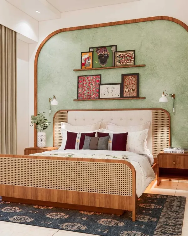 Colorful ethnic vibes in this stunning master bedroom. The design features a beautiful cane and wood bed frame, a sage green textured accent wall with an arch detail, and a curated collection of traditional Indian art.