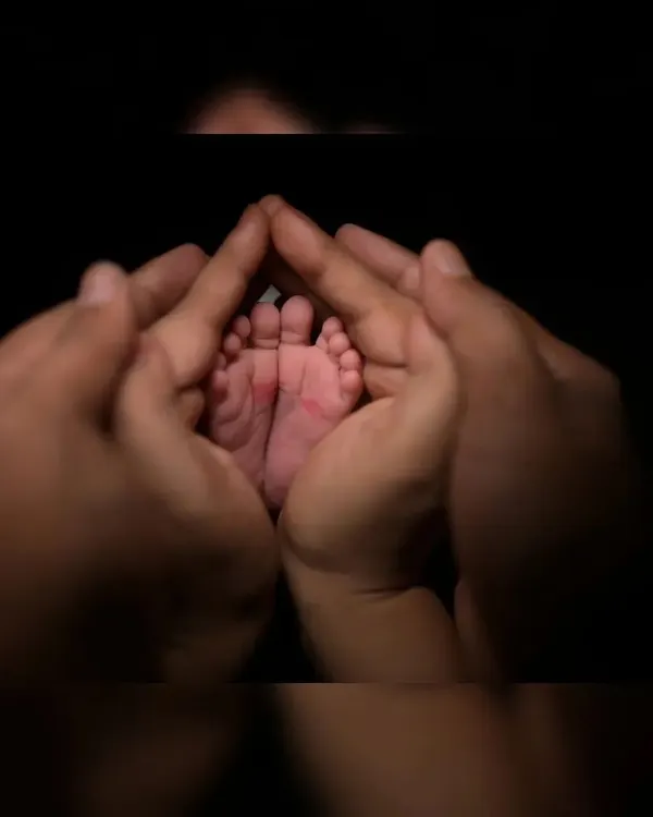 There is nothing more precious than tiny newborn feet. I use focused lighting to capture these delicate details, framed by the parents' hands to show scale and love.