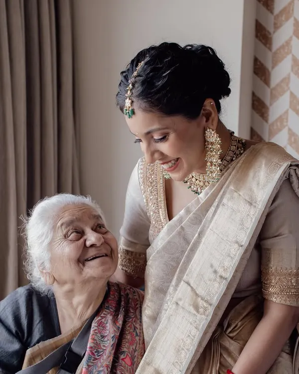 A priceless moment of love between generations. The bride shares a warm, genuine smile with her grandmother, a memory to be treasured forever.