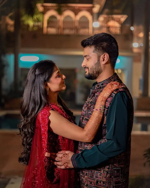 A romantic portrait of Ashri and Nayan during their Sangeet night. The warm lighting and their close embrace create a beautiful, intimate moment amidst the celebration.