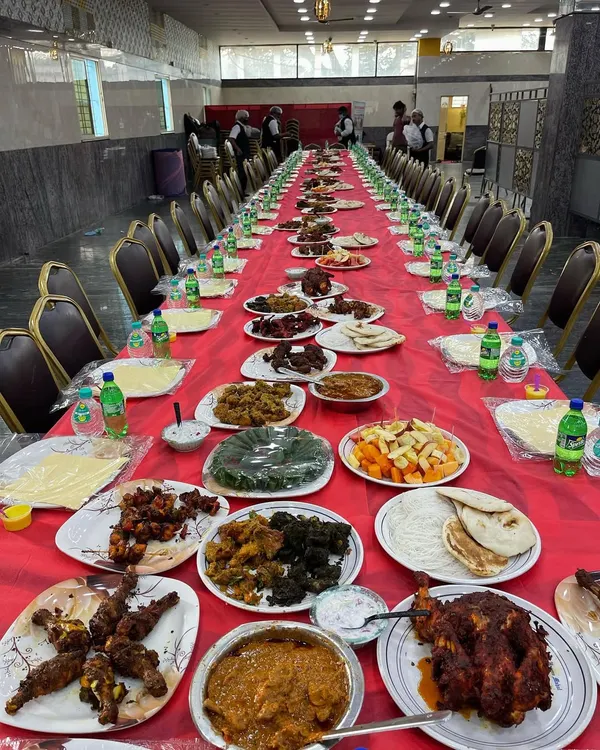 A complete Dastarkhwan setup ready for a wedding reception. The long table is laden with a variety of our best dishes, including multiple chicken starters, mutton curries, fruit salad, and fresh bread, ensuring a feast for the eyes and the palate.