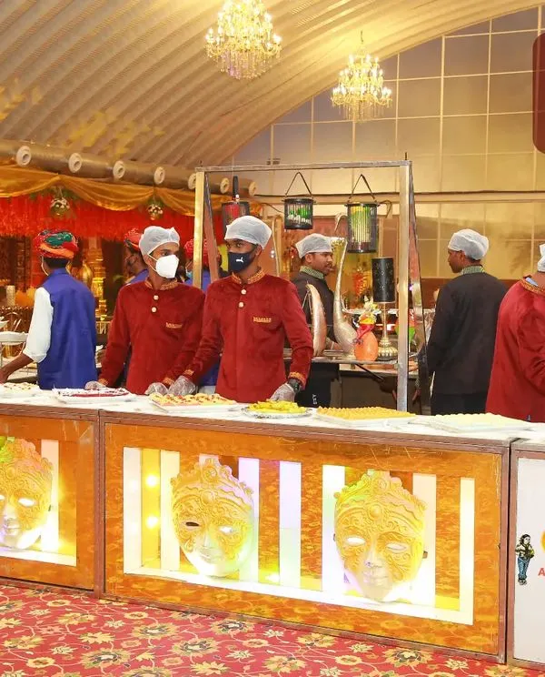 A beautifully lit food counter with decorative masks, ready for an evening reception. I believe the service of food is the service of energy, and the presentation should reflect that.