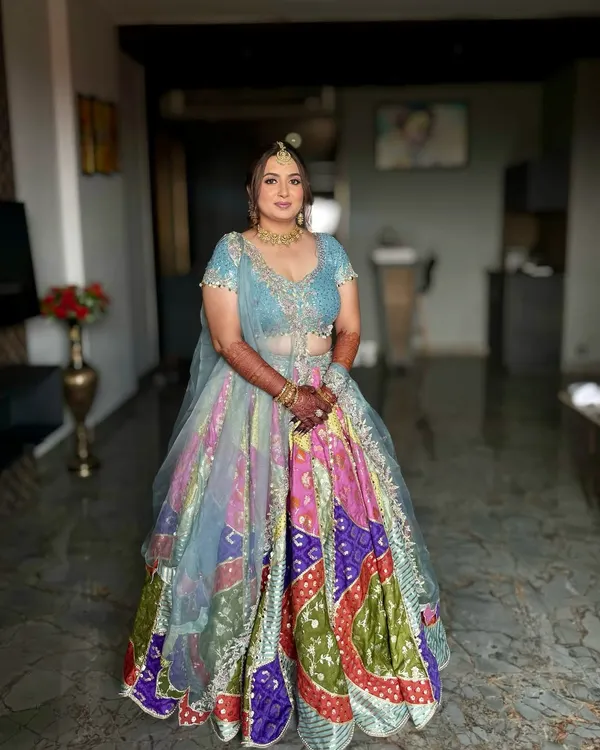 A beautiful Haldi look for Dhruvi. The makeup is fresh and minimal, with a pop of color on the eyes to complement her vibrant, multi-colored lehenga.