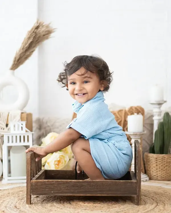 That happy smile is what we live for. This portrait was taken in our bohemian-style studio setup, which provides a neutral and warm background for toddler photos.