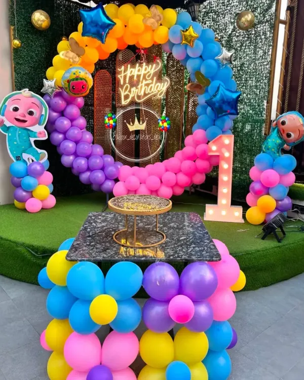 This Cocomelon themed first birthday party is one of my popular requests. It includes a colorful balloon ring, Cocomelon character cutouts, and a light-up number '1' for the special milestone.