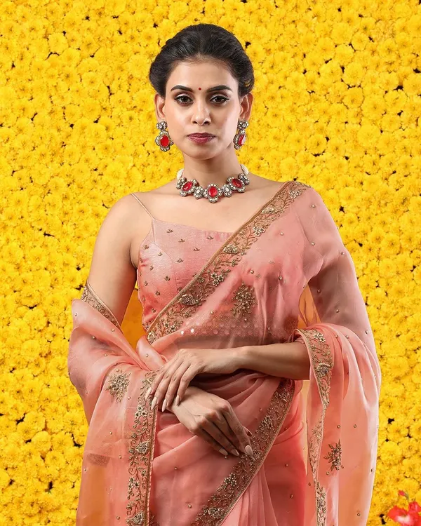 Feminine and flamboyant, our peach organza saree is a breathtaking masterpiece. The delicate embroidery and sheer fabric create a look of ethereal beauty.