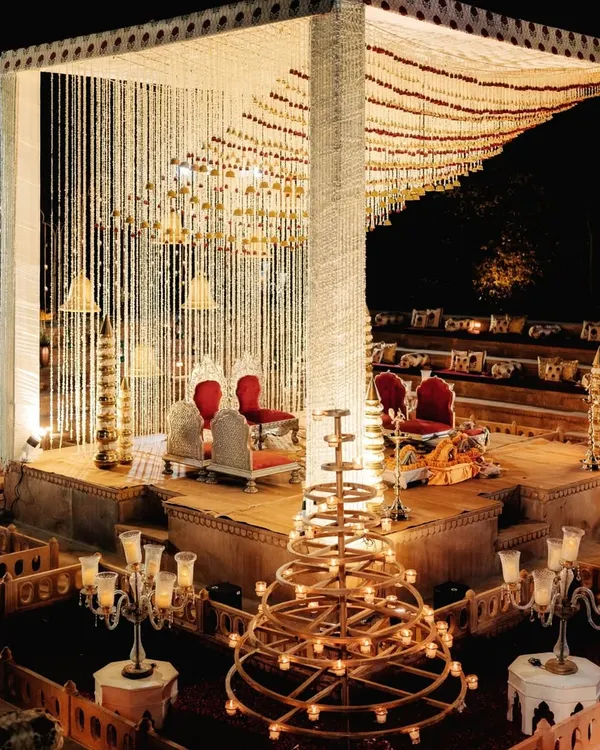An architectural mandap set within a traditional step-well structure for a royal Marwar wedding. The design uses vertical space and lighting to create a sense of grandeur and heritage, perfect for a regal ceremony.