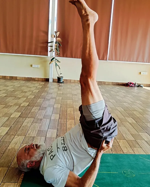 Here is a student who is 65+ holding a strong Sarvangasana (Shoulder Stand). This demonstrates that with proper guidance, age is no barrier to practicing even advanced asanas for incredible health benefits.