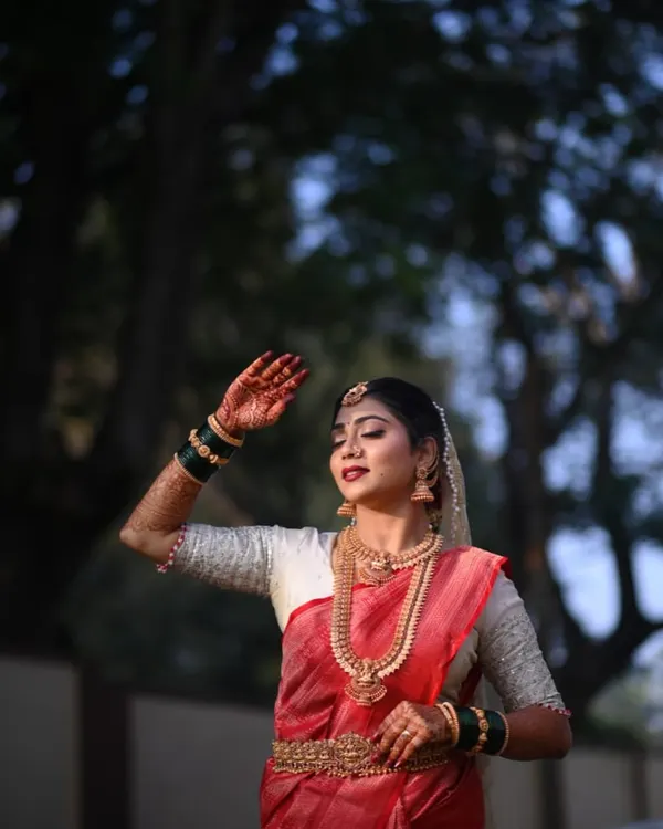 This is the feeling I aim for with every custom bridal outfit. Here, the bride is radiant in a traditional red saree paired with a contrasting white blouse featuring delicate, handcrafted embroidery for her special day.