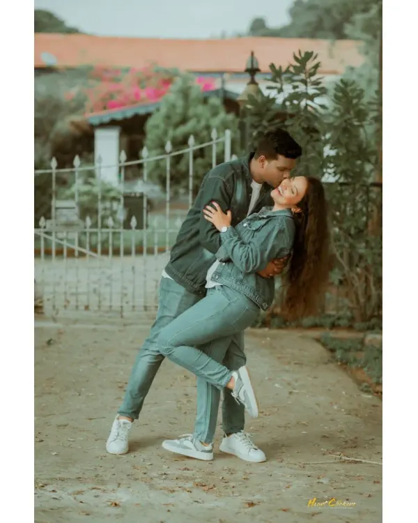 A fun and spontaneous moment as a couple in matching denim outfits shares a playful dip. This candid shot is full of energy and genuine affection.