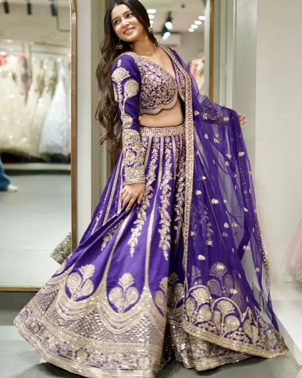 In the language of colors, this lehenga says majestic. A stunning royal purple lehenga with intricate silver and gold embroidery that creates a look of pure royalty.