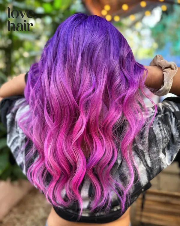 This is the kind of hair magic we live for. We created this vibrant purple to pink ombre melt using a bleach and tone technique, finishing with soft waves to show off the seamless color transition. This is for you if you're ready to be the main character.