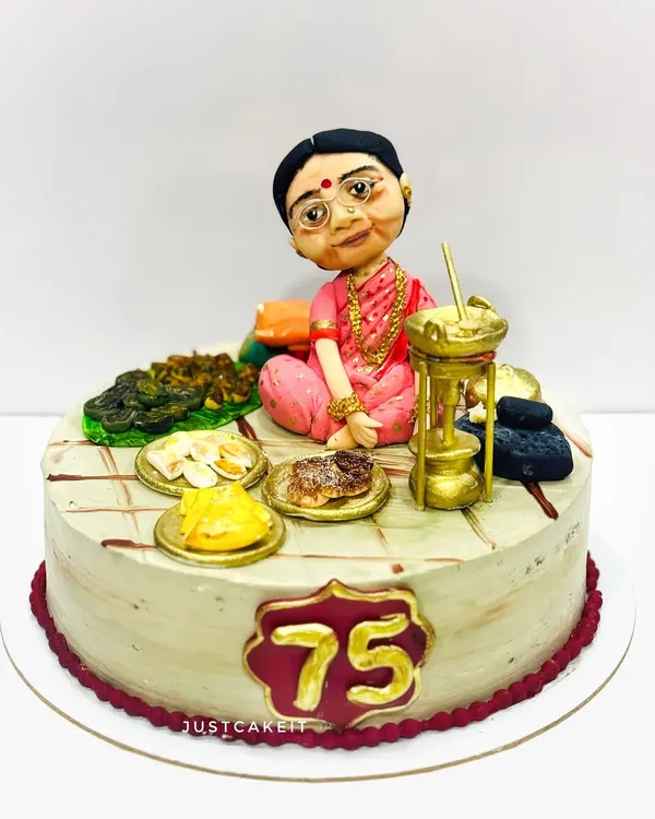 A very special cake for a 75th birthday, featuring a hand-molded caricature of the beloved 'Aai' (mother) surrounded by her favorite traditional foods, all edible.