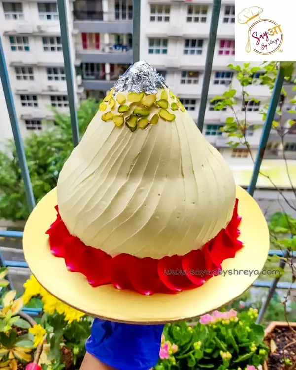This is my showstopper for the festival: a cake sculpted and frosted to look exactly like a traditional modak. Garnished with pistachios and edible silver leaf (vark), it makes for a truly memorable centerpiece for your Ganesh Chaturthi celebrations.