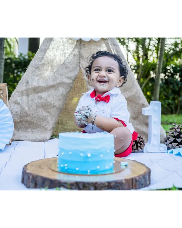 The pure delight of a first birthday cake smash. Little Ayansh is all smiles, covered in blue frosting during his outdoor milestone session. I love capturing these messy, happy moments.