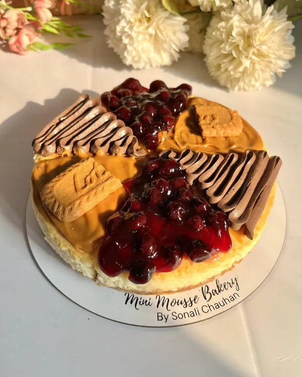This is my pride and joy, the assorted eggless baked cheesecake. It features a rich, creamy texture and a crisp biscuit base, with slices of my homemade blueberry compote, decadent chocolate, and spiced Lotus Biscoff.