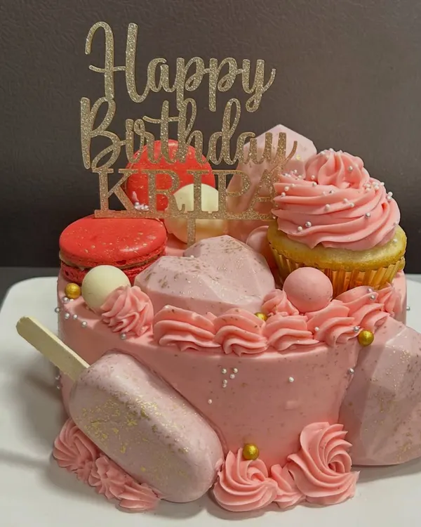 This cake is a party in itself! I went all out with pink frosting, a cakesicle, macarons, and geometric hearts for a truly extravagant birthday celebration.
