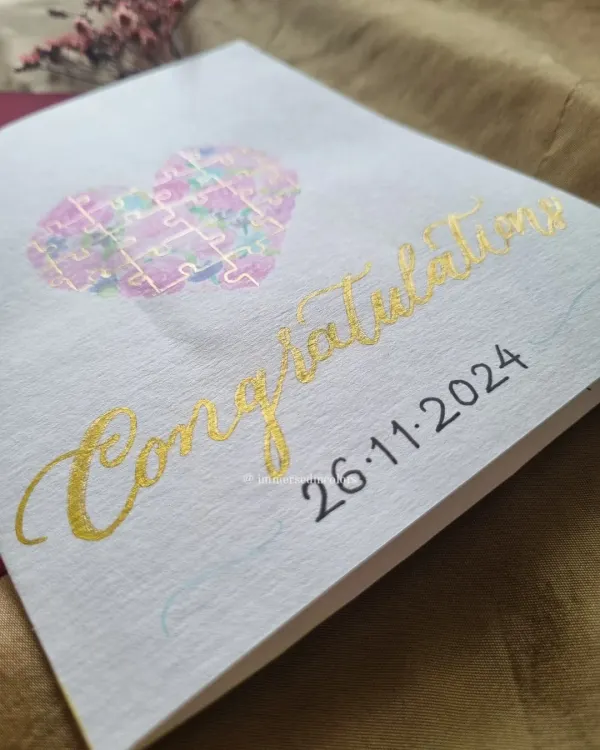 This congratulations card was made for a couple who loves jigsaw puzzles. I painted a watercolor heart filled with puzzle pieces and finished it with gold calligraphy.